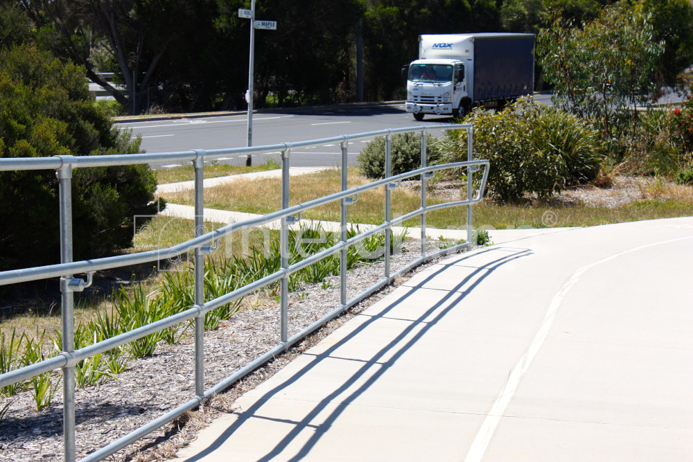 Modular handrail installed on bike path with highway behind